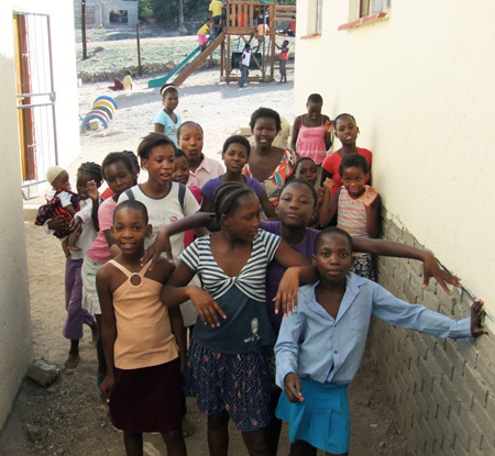 Die Kinder sitzen im Schatten der H�user
